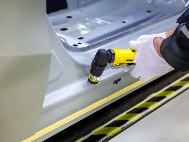 Mirka AOS 130NV spot repair sander in use on car paint