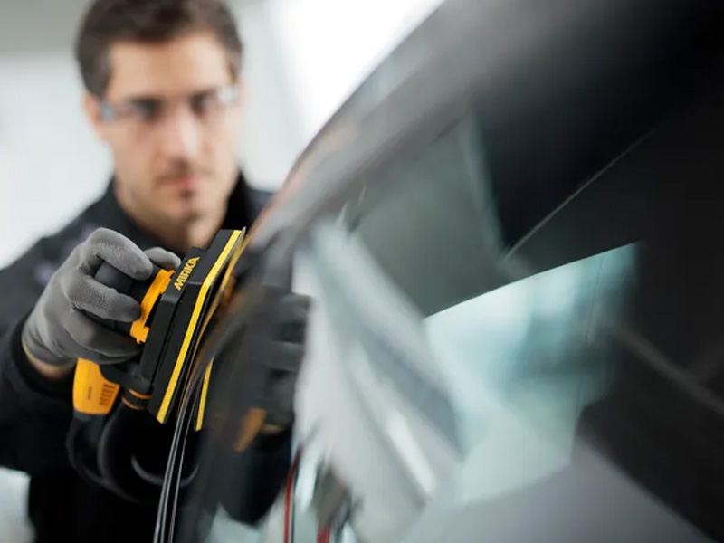 Mirka DEOS 383CV sander in use on car panel sanding